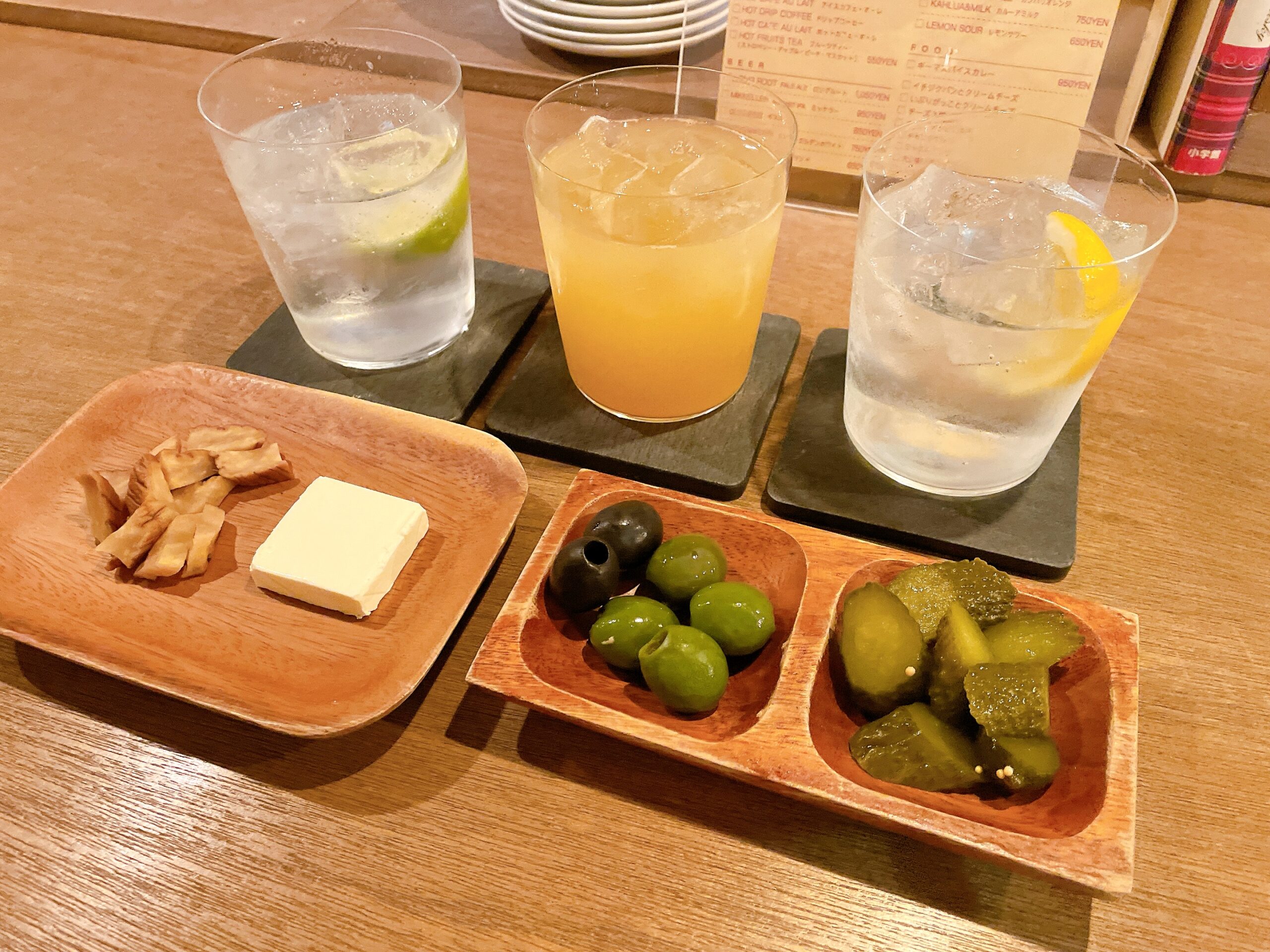 《ドリンク》
（右）レモンスカッシュ
（中）オレンジジンジャー
（左）ライムトニック

《単品メニュー》
（右）オリーブとピクルス
（左）いぶりがっことクリームチーズ

この取材で、初めて『いぶりがっこ』を食べました😋 燻製の味とセットになっているクリームチーズのまろやかさが相性抜群で美味しかったです！