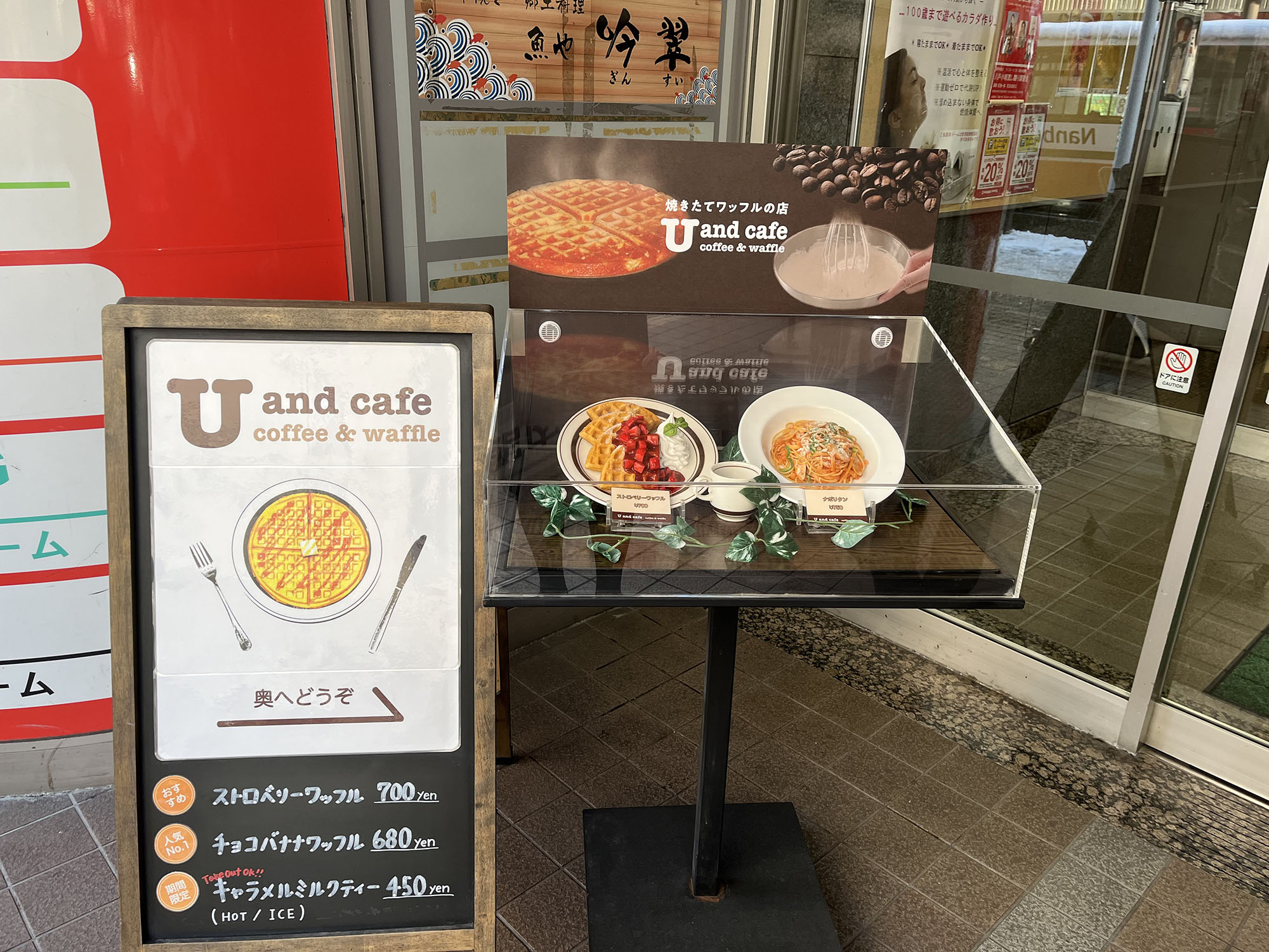 お店の外にあるユーアンドカフェの看板と商品レプリカ